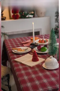 Detail shot of a thick red and white checkered tablecloth with a festive holiday setting