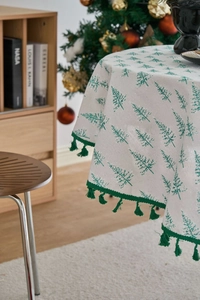 Close-up of pine tree print tablecloth with green tassels for Christmas decor