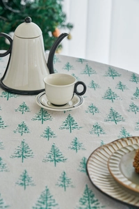 Close-up of pine tree print on cotton linen tablecloth with vintage ceramic teapot