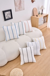 Detailed view of colorful vertical striped embroidery on square cotton linen pillow covers