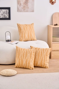 Detail of three mustard yellow floral pattern cushion covers on a modern white sofa