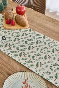 Detail of Christmas table runner with pine needles, red berries and gold glitter