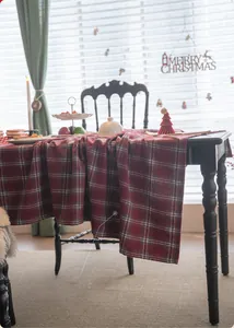 Detail of thick red plaid tablecloth fabric showing warm Christmas holiday dining ambiance