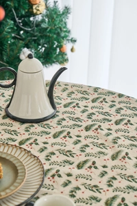 Close-up of pine needles and red berries print on cotton linen Christmas tablecloth
