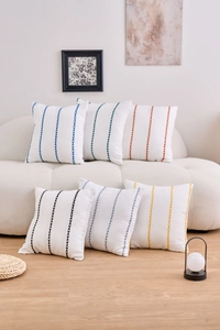 Detailed view of white canvas cushion covers with colorful geometric vertical embroidery