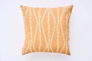 Detail of mustard yellow square cushion cover with white floral vine print texture