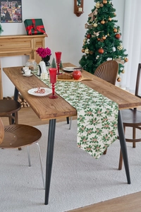Detail of Christmas table runner with holly leaves on a festive holiday dining table