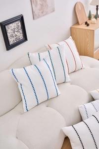 Detail of geometric V-shaped embroidery on heavy fabric cushion cover in modern home setting