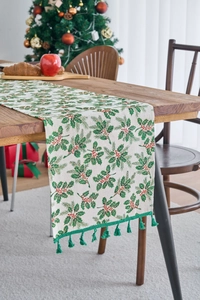 Detail of Christmas table runner with green holly leaf prints and fringe tassels