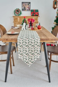 Detailed texture of Christmas table runner with green pine needles and red berries motifs