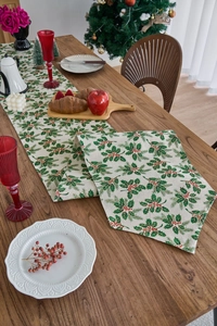 Close-up of Christmas table runner with holly leaves and berry patterns on cotton linen