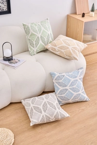 Detail of four geometric leaf pattern cushion covers in green, yellow, blue, and grey colors