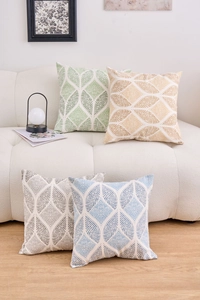 Detail view of four geometric pattern linen cushion covers in green orange grey and blue