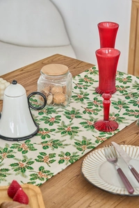 Detail of Christmas table runner with holly leaf print and gold stamping on cotton linen