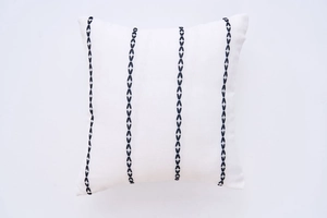 Detail of white cotton linen cushion cover with black geometric embroidered lines
