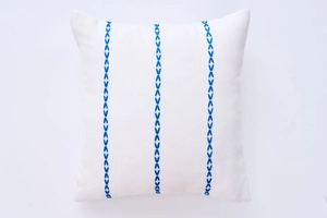 Close-up of geometric blue embroidery on white linen cotton square pillow cover