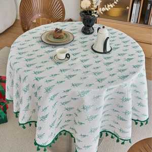 Round pine print tablecloth with green tassels for festive dining room decor