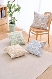 Detail view of modern geometric cushion covers in grey, green, yellow, and blue colors