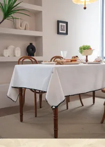 Detail of white rectangular tablecloth with black scalloped embroidery edge and premium drape