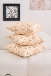 Detail of floral patterns on square cushion covers stacked on a white textured sofa
