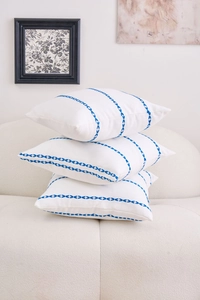 Detailed close-up of blue geometric embroidery on premium white cotton pillow covers