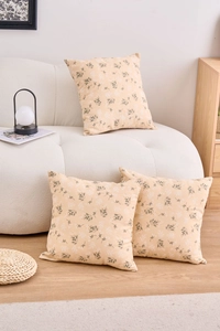 Detailed texture of cotton linen cushion covers with black floral patterns on beige fabric