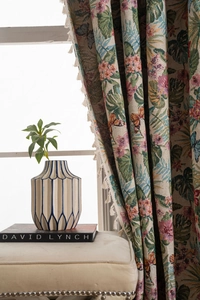 Detailed view of jacquard curtain with floral bird patterns and white fringe trim edges