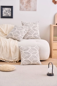 Close-up of geometric gray patterns on white cushion covers in a minimalist home setting