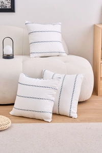 Detail of embroidered blue leaf patterns on beige cotton linen cushion cover fabric