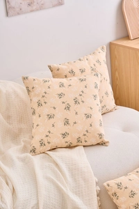 Detailed texture of beige floral cushion covers set on a cozy white fabric sofa