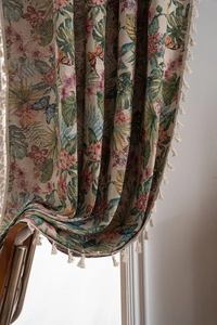 Close-up of jacquard fabric curtains with floral bird patterns and beige cotton tassels