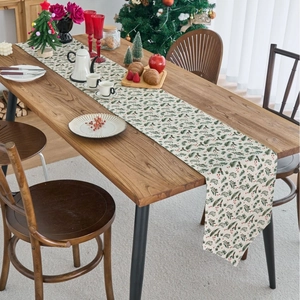 Christmas table runner with pine needles and red berries on a rustic wooden table
