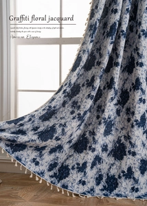 Detailed close-up of blue floral jacquard fabric with elegant tassel fringe edge