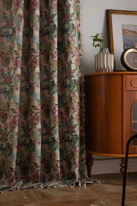 Detail of vintage floral jacquard curtain with colorful bird patterns and fringe tassels