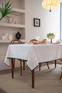 Close-up of white rectangular tablecloth with black wavy edges in a minimalist dining room