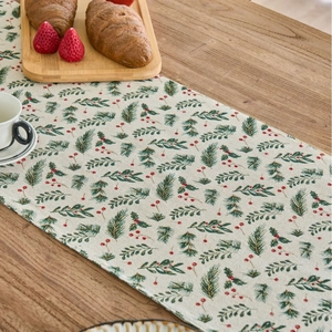 Christmas green pine leaf table runner on rustic wooden dining table with berries