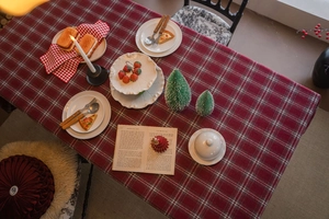 Close-up of thick red plaid tablecloth with festive winter dinner table setting
