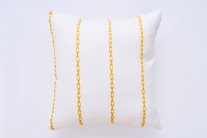 Detailed view of white throw pillow cover with vertical yellow geometric embroidery pattern