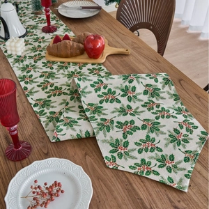 Christmas table runner with green holly and red berries pattern on linen texture fabric