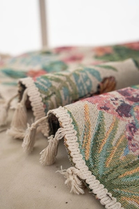 Macro detail of bird and floral jacquard curtains with delicate white fringe tassels