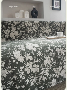 Detail of green floral sofa cover with jacquard texture shown in cozy home setting