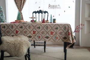 Detailed close-up of Christmas jacquard tablecloth with festive bells and red bows