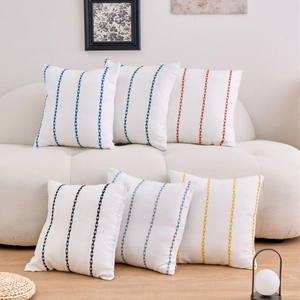 Bohemian woven pillow covers with geometric embroidery on a stylish cream sofa