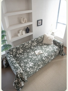 Detail of dark green floral sofa throw cover with thick woven texture and small flowers
