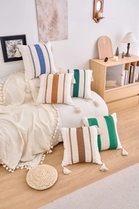 Detailed view of bohemian woven pillowcase with colored stripes and cotton tassels