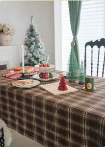 Gros plan sur la nappe à carreaux marron foncé avec une ambiance de fête hivernale