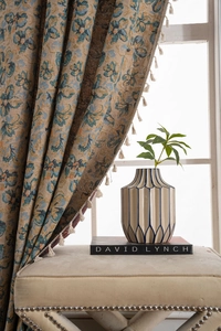Detailed view of European vintage floral jacquard curtain fabric with cream tassel fringe