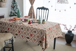 Macro shot of jacquard Christmas tablecloth featuring red bows and green tree patterns
