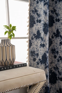Detail of blue floral curtain with beige tassels and premium cotton linen fabric texture