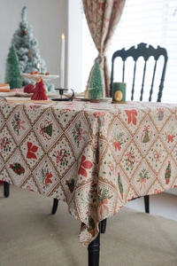 Close-up of Christmas jacquard tablecloth with festive bow and tree patterns on beige fabric